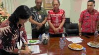 Caption Foto : Sekda Lynda Watania menanda tangani Dokumen SSK disaksikan Kadis Kominfo Recky Laloan (Batik Merah Tengah) dan Jajaran Tim SSK.(Doc Foto : Ist)